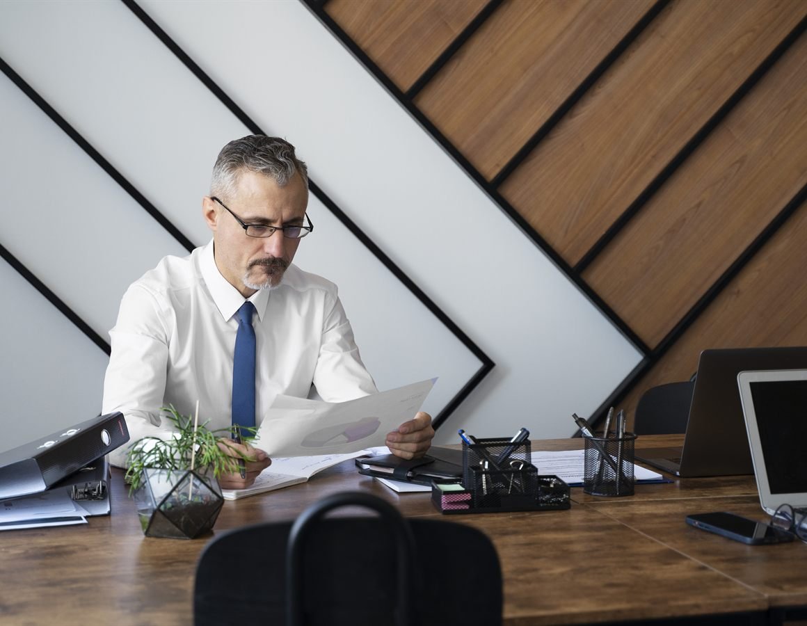 Contador do Centro de Estratégias Empresariais analisando documentos no escritório